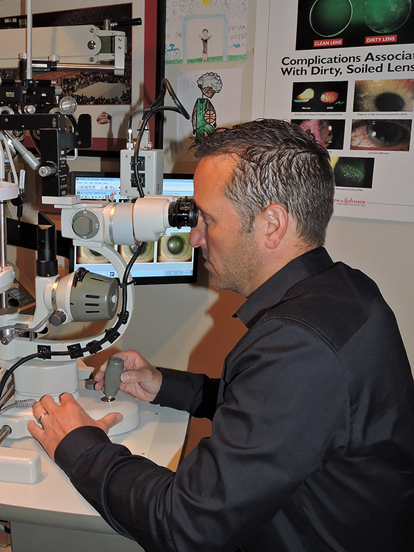 photo of doctor sean kull optometrist looking through optometry equipment while performing an exam