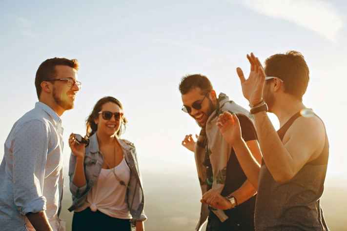 photo of four young adult friends wearing glasses and sunglasses in sunlight