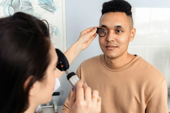 photo of an optometrist examining an eye of a patient in an optometrists office